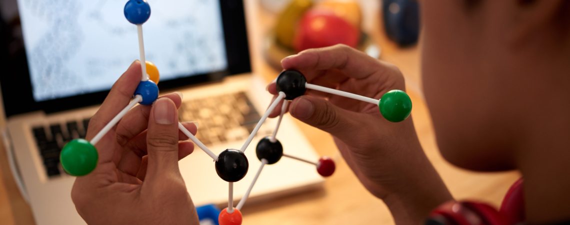 Close-up image of chemical element model in hands on student