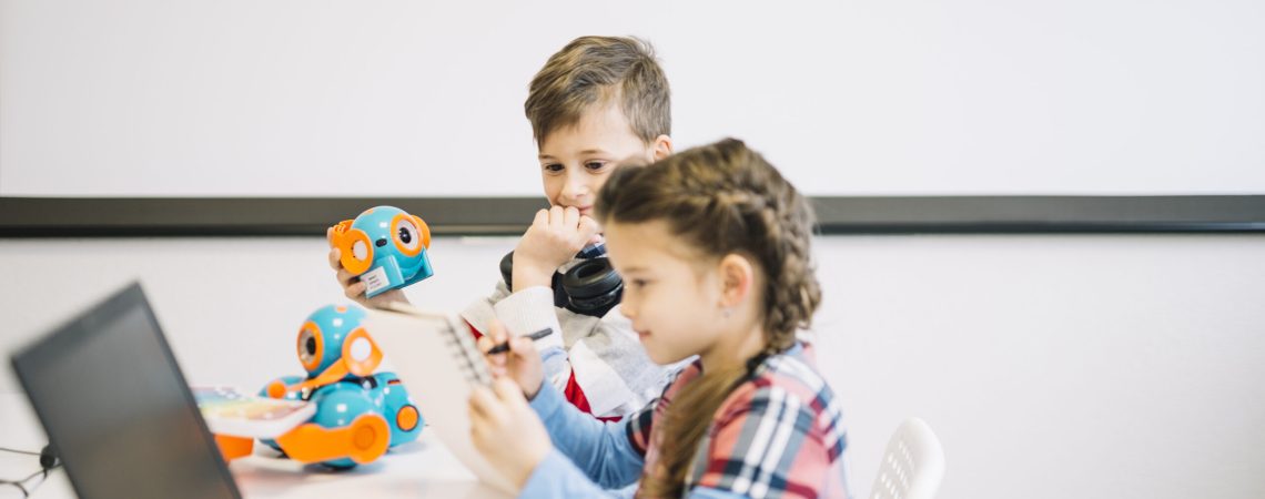 little-boy-looking-girl-drawing-notebook-with-pen-classroom
