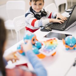 portrait-smiling-boy-with-laptop-desk-looking-camera